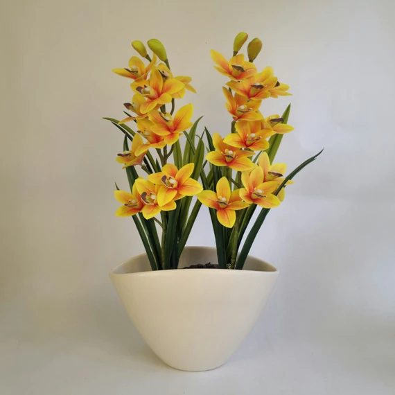 Narancssárga műorchidea két ággal, vajszínű kaspóban, mulccsal díszítve 